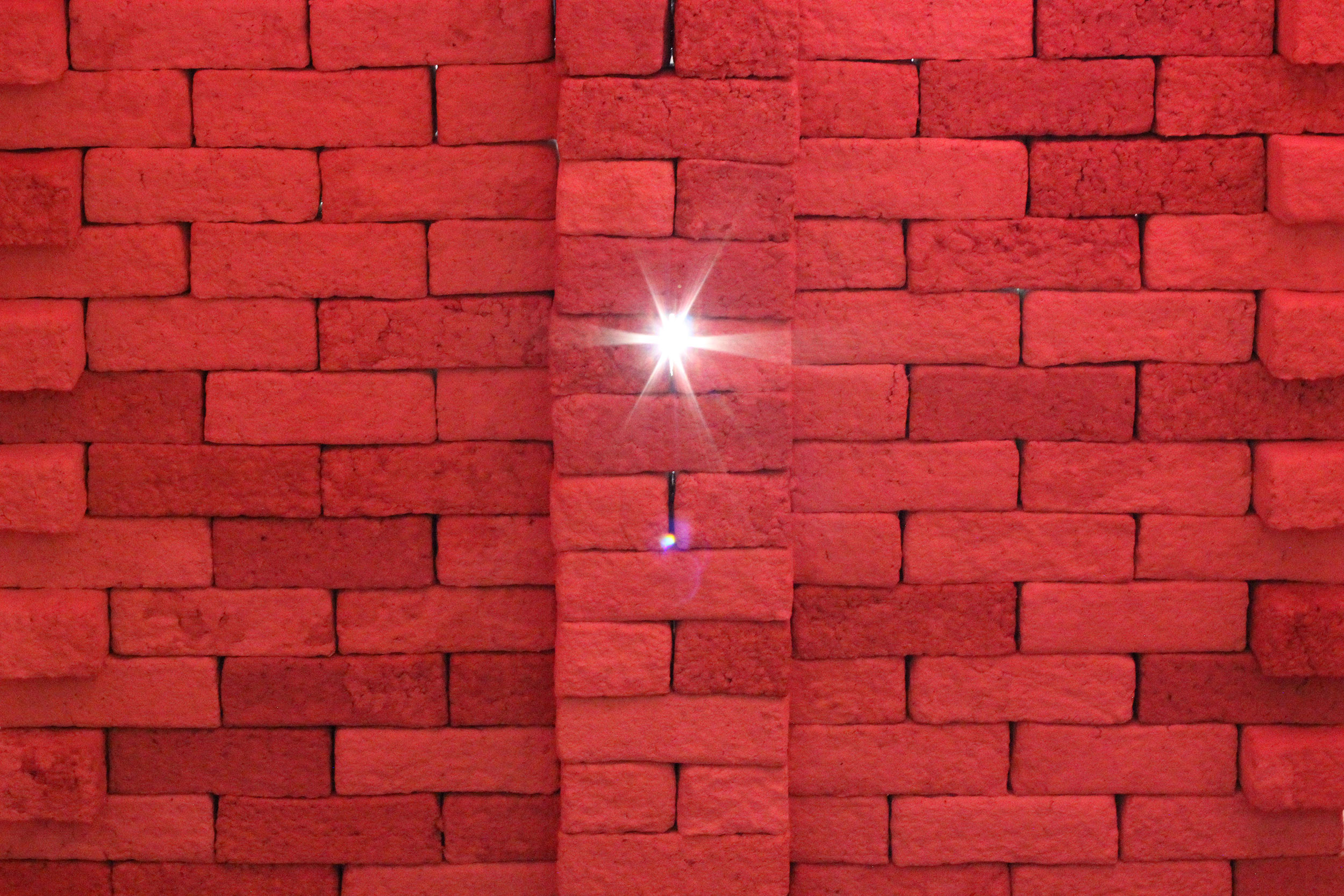 Wackelige Mauer, von hinten beleuchtet und in rötliches Licht getaucht